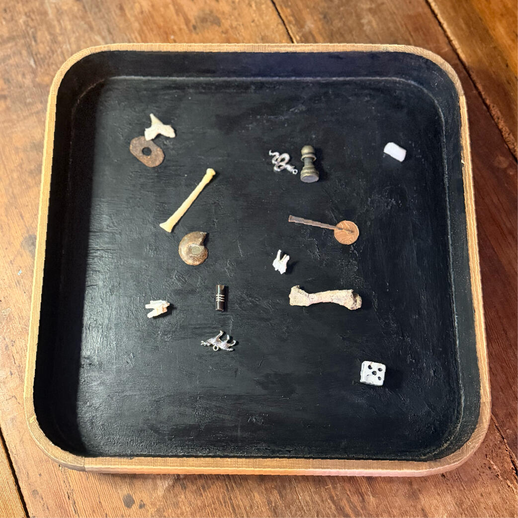 Handmade age-waxed casting tray holding charms and bones, Cast & Ask castulum by WMFrewolfe