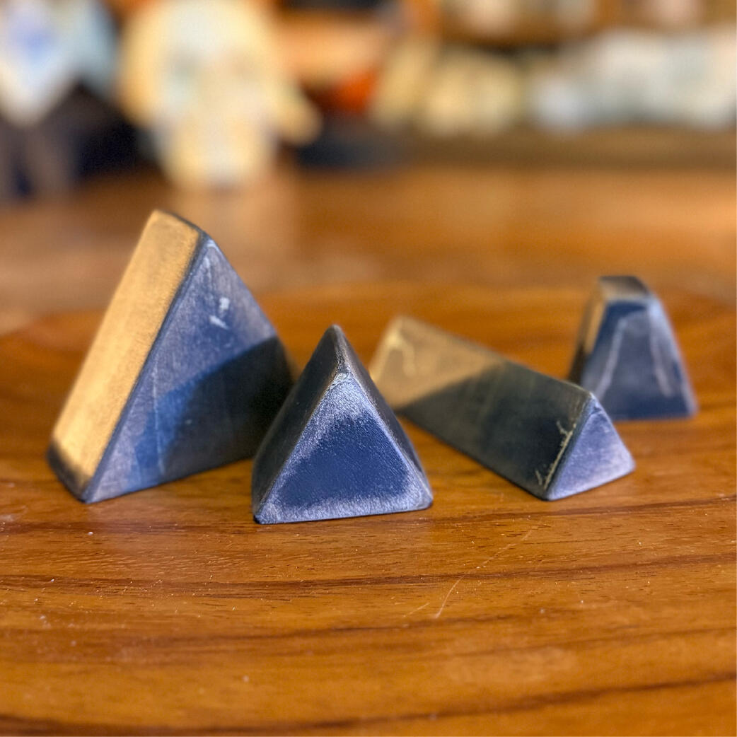 Row of standing bone bells in varied shapes and finishes, sealed wooden rattle totems, WMFrewolfe
