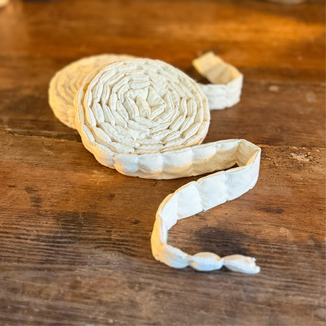 Handmade segmented salt-filled cloth cord coiled with its tail unspooled, reusable salt ward, two shown, Saltcord by WMFrewolfe